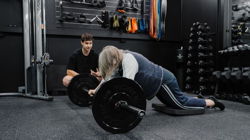 Personal trainer coaches a member through a barbell strength exercise at Habitat Gym Prestons, focusing on proper technique and safe movement. 