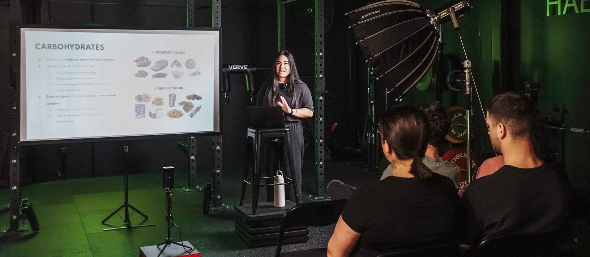 Coach leading a nutrition workshop at Habitat Gym, explaining the role of carbohydrates in fitness and performance