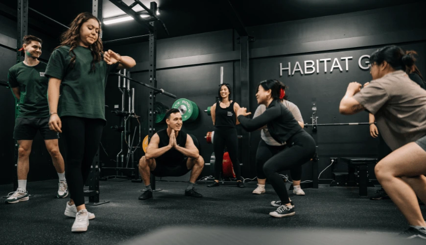 Gym members doing squats with coaches at the Habitat Gym in Prestons