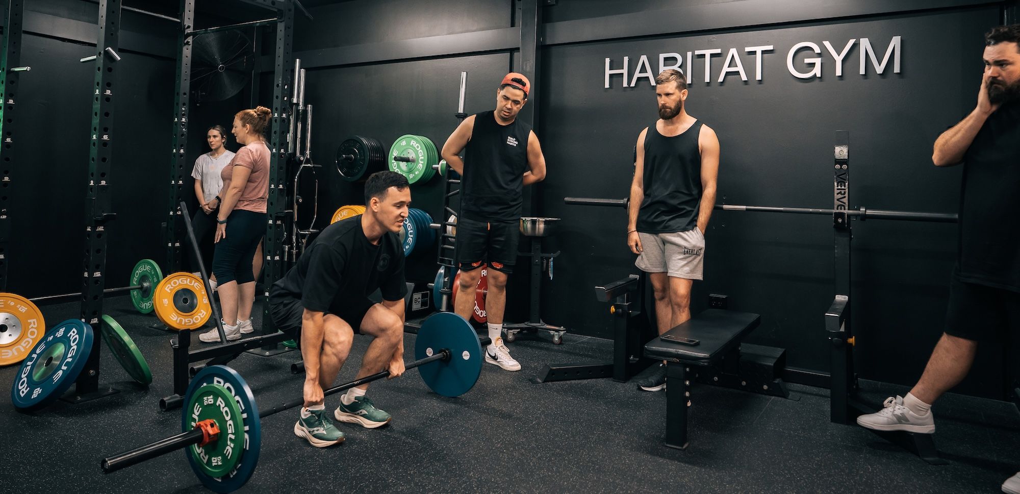 Coach Ben showing proper form of deadlift to gym members during a weightlifting workshop at Habitat Gym in Western Sydney