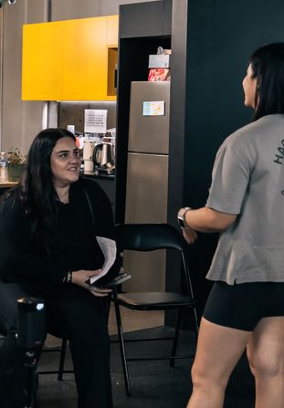Member chatting with Coach Jeannie after a community workshop inside Habitat Gym