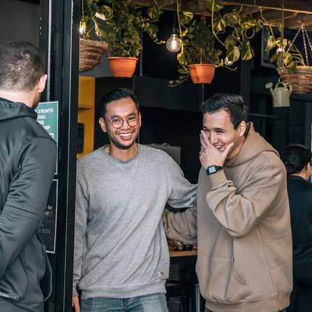 Coach Ben with client laughing in front of Habitat Gym in Western Sydney