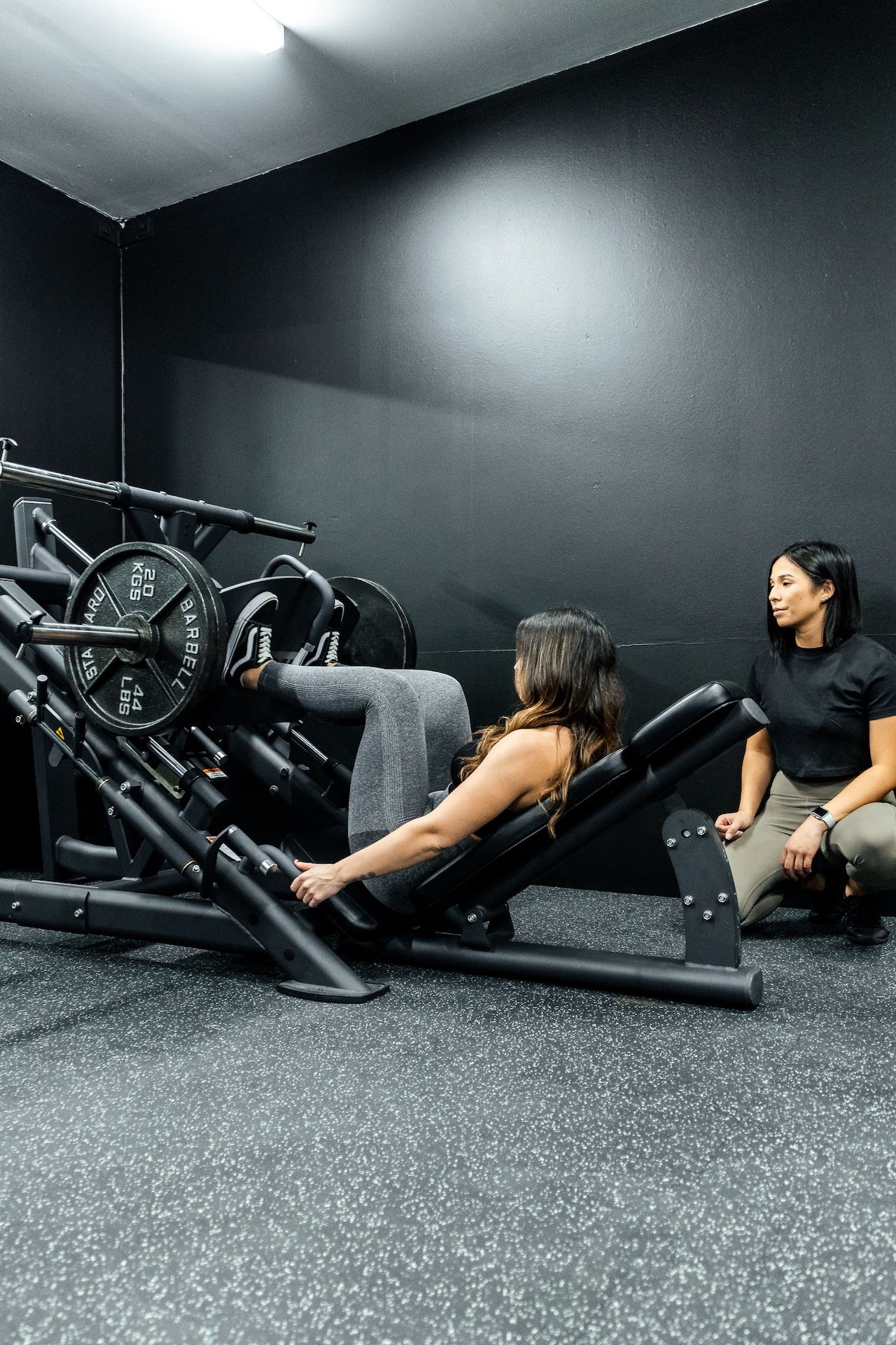 Personal training session with Coach Jeannie supervising leg press at Prestons gym